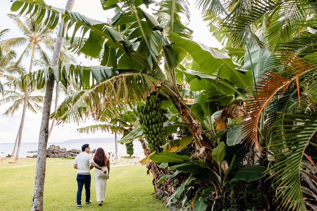 William guiding Roshni down to the floral path and Marry Me marquee letters that sit in front of the ocean.