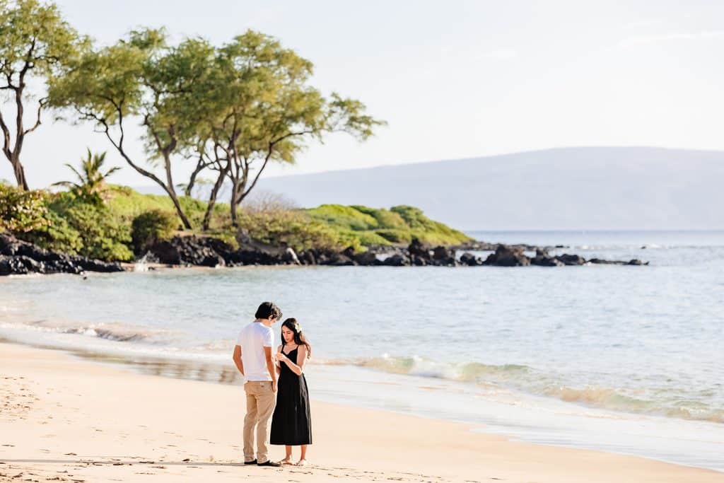 Alejandra opening up the message in the bottle as Hector looks down and anxiously waits for her to finish reading it. 