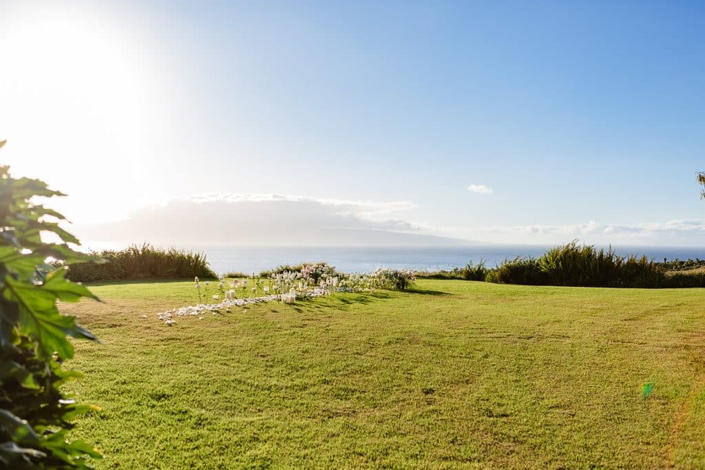 A landscape photo of the lookout covered in a floral pathway and the ocean view behind them. 