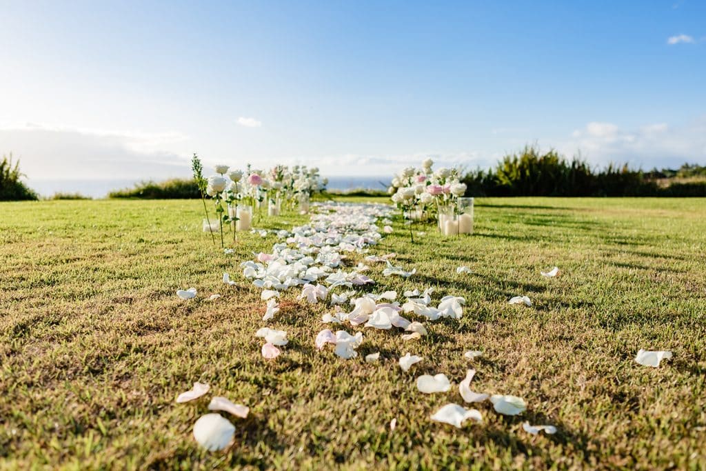 A closeup photo of the flower petals lining the grass to the flower and candlelit path.