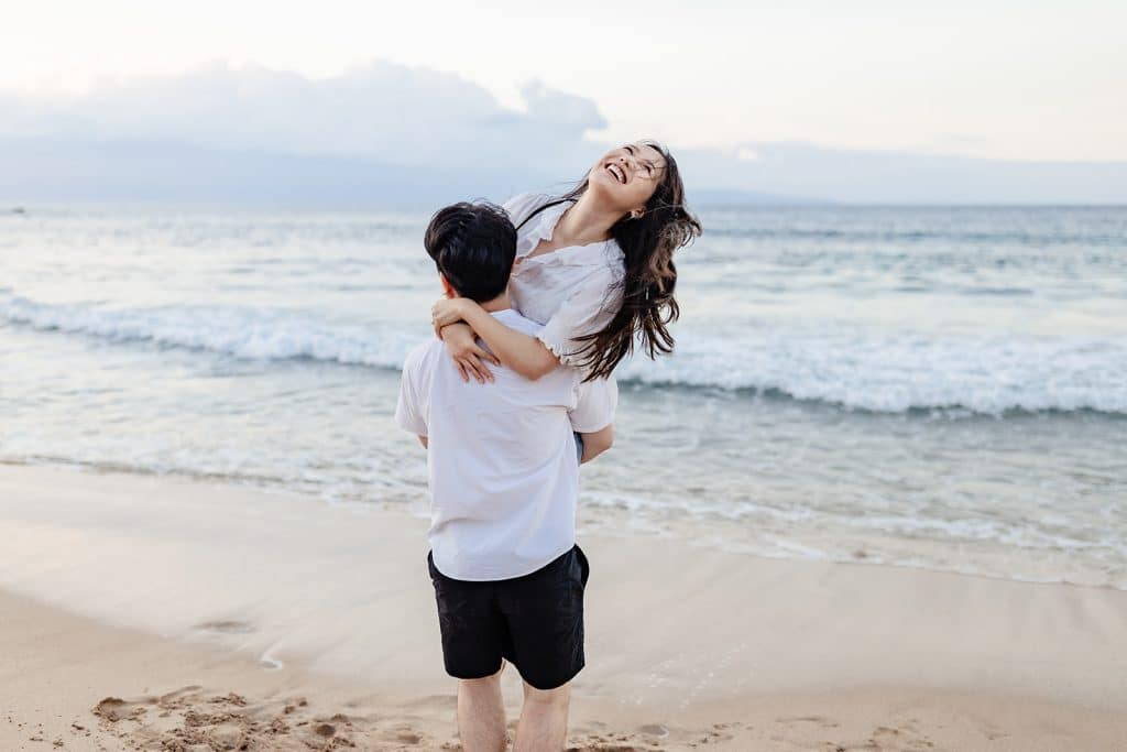 Aaron lifting Shunshun up and spinning her around as she looks up into the sky and laughs