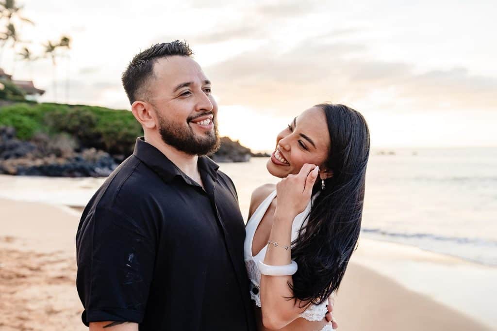 Brandon talking and laughing while holding Alexis around the waist as she looks up smiling at him.