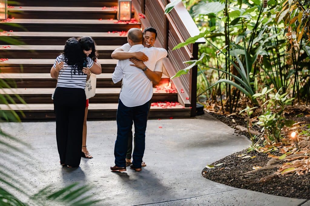 Denise and Raynell hugging their friends at the bottom of the stairs of the treehouse after getting engaged.