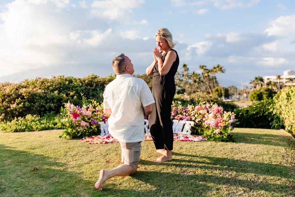 Joy smiling down at Andy as he is down on one knee and smiling at her. 
