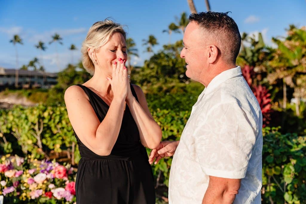 Joy holding her face in her hands and holding back tears as she smiles at Andy who is smiling at her.